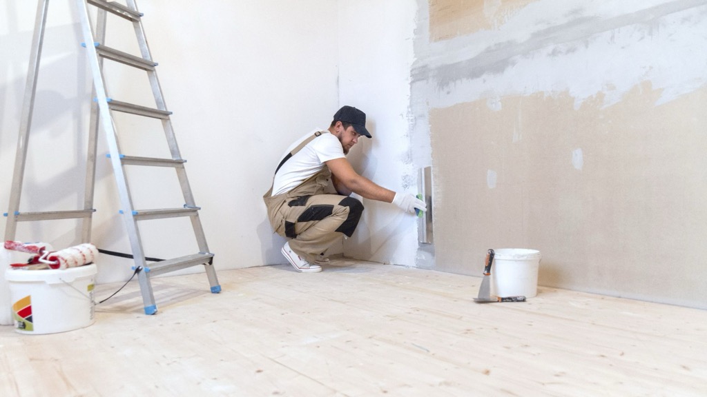 Artisan plaquiste posant des plaques de plâtre sur ossature métallique — Bayonne